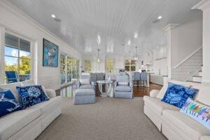 A bright and spacious living room decorated with white furniture and pastel blue accents.