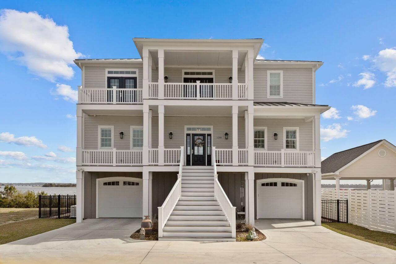 Photo of 3 Storey beige waterfront home, with 2 car garage and grand stairwell entry.