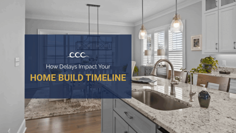 Modern coastal kitchen with white cabinets, marble countertops and blue accents designed by Crystal Coast Construction.